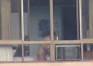 Aged woman naked in the window stretching 2